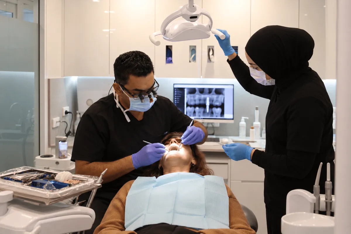 Dentist and assistant treating a patient at Hayat Dental